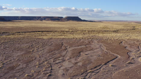 low altitude drone flight over a dusty badland in arizona