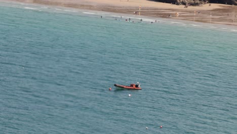 Hand-held-shot-of-an-anchored-RIB-boat-off-the-coast-of-Towan-Beach,-Newquay