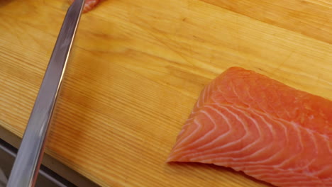 a chef slices a salmon fillet. raw seafood