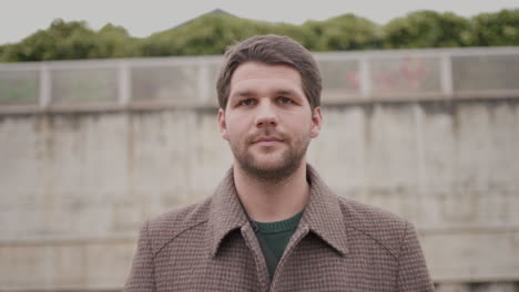 portrait of young stylish man on a train platform, train moving behind