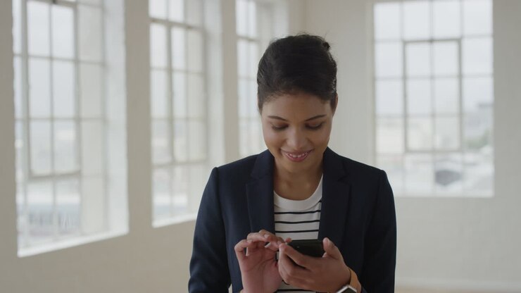 portrait of young mixed race woman using smartphone texting browsing on mobile phone messages networking female business entrepreneur enjoying digital communications