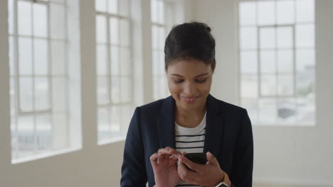 Retrato-De-Una-Joven-Mujer-De-Raza-Mixta-Que-Usa-Mensajes-De-Texto-En-Un-Teléfono-Inteligente-Navegando-En-Mensajes-De-Teléfonos-Móviles-Empresaria-De-Negocios-Que-Disfruta-De-Las-Comunicaciones-Digitales