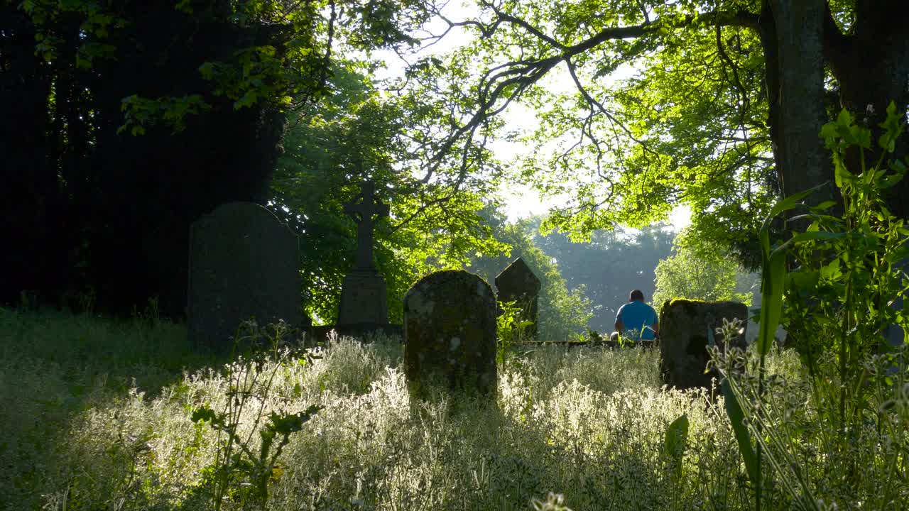 아일랜드 의  ⁇ 스포드 카운티 에 있는 버려진  ⁇ 트 묘지 에 앉아 있는 한 사람 의 뒷면