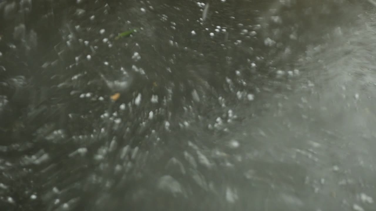 차량에서 본 아스팔트 위에 쏟아지는 심한 우박