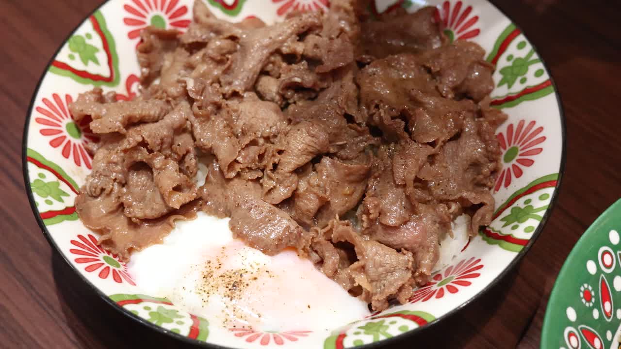 Various Thai rice dishes with vibrant toppings and garnishes are arranged on a wooden table under bright lighting, captured in smooth overhead camera movement