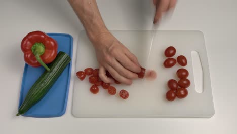 hombre cortando tomates ciruela con cuchillo