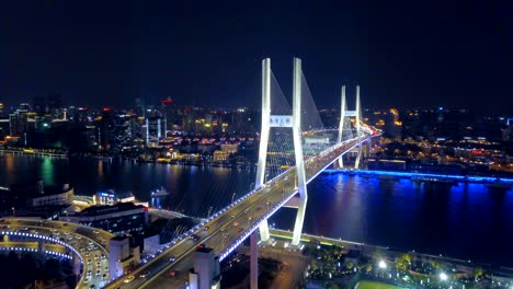 aerial view of roundabout of nanpu bridge, shanghai downtown, china. financial district and business centers in smart city in asia. top view of skyscraper and high-rise buildings at night.