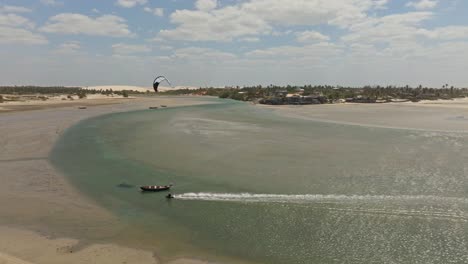 kitesurfista haciendo un truco por encima de un barco en una laguna vacía en brasil