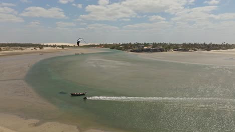 kitesurfer doing a trick above a boat in an empty lagoon in brazil