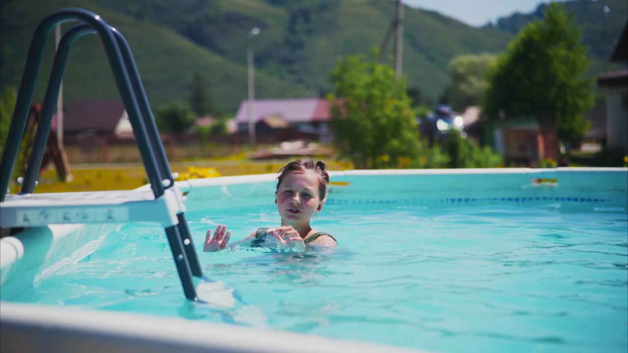 Young Girl Swimming and Relaxing in Outdoor Pool on Sunny Day