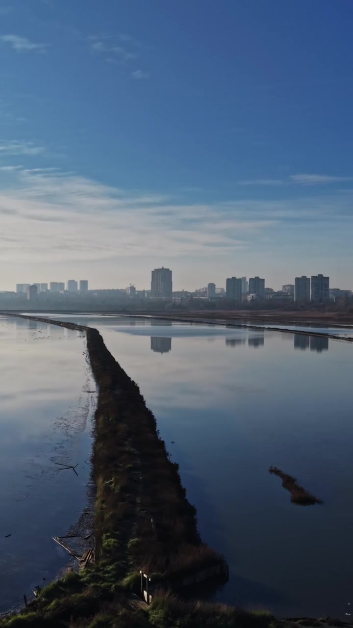 Produção de sal em área costeira com edifícios e reflexos na água