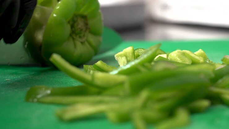 Fresh Green peppers cut and chopped by chef in restaurant kitchen