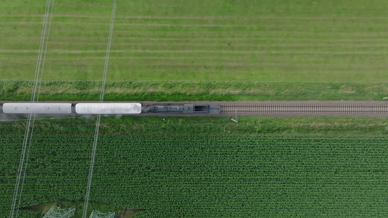 Aerial view of a train passing through agricultural fields