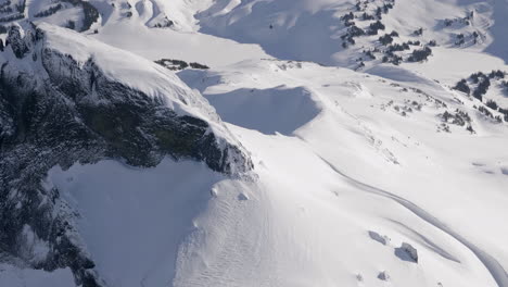 Vista-Aérea-De-La-Famosa-Montaña-De-Colmillo-Negro-Cubierta-De-Nieve-Durante-El-Día-Soleado-En-La-Cima-De-La-Montaña