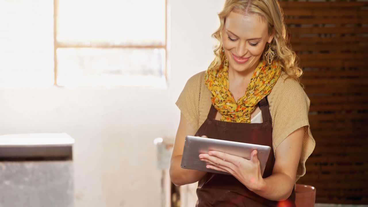 Beautiful female potter writing in notebook