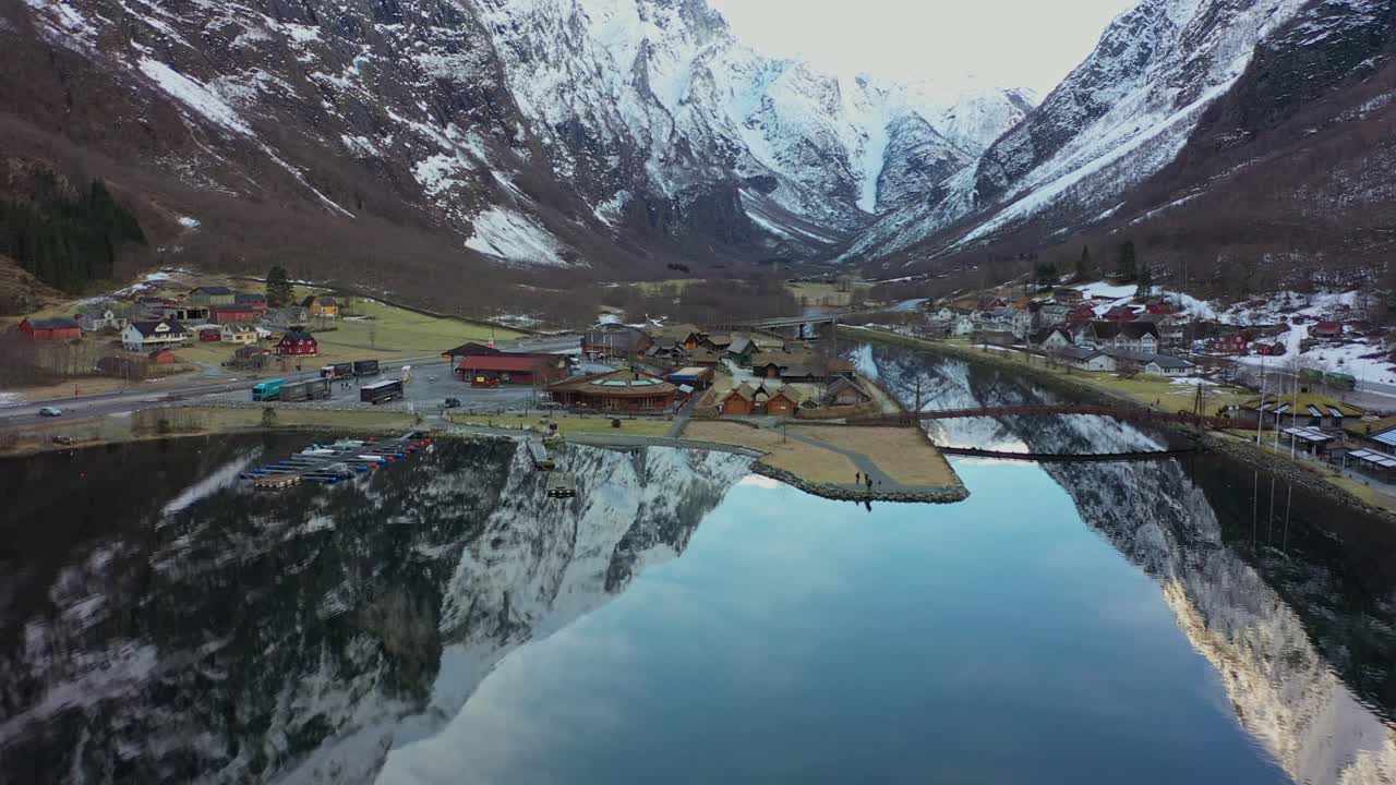 hermosa antena de la aldea de gudvangen con un valle de montaña en el fondo y hermosos reflejos en un fiordo cristalino en primer plano - antena de invierno de gudvangen noruega