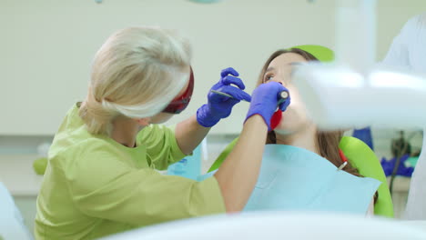 dentista trabajando con lámpara de polimerización dental en la cavidad oral