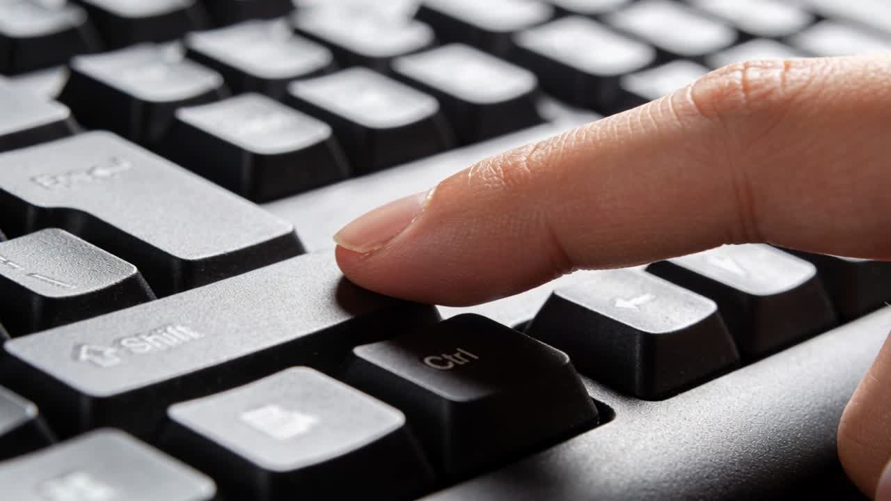 Approaching right index fingertip tapping Ctrl key at workstation, showing Shift and Windows key