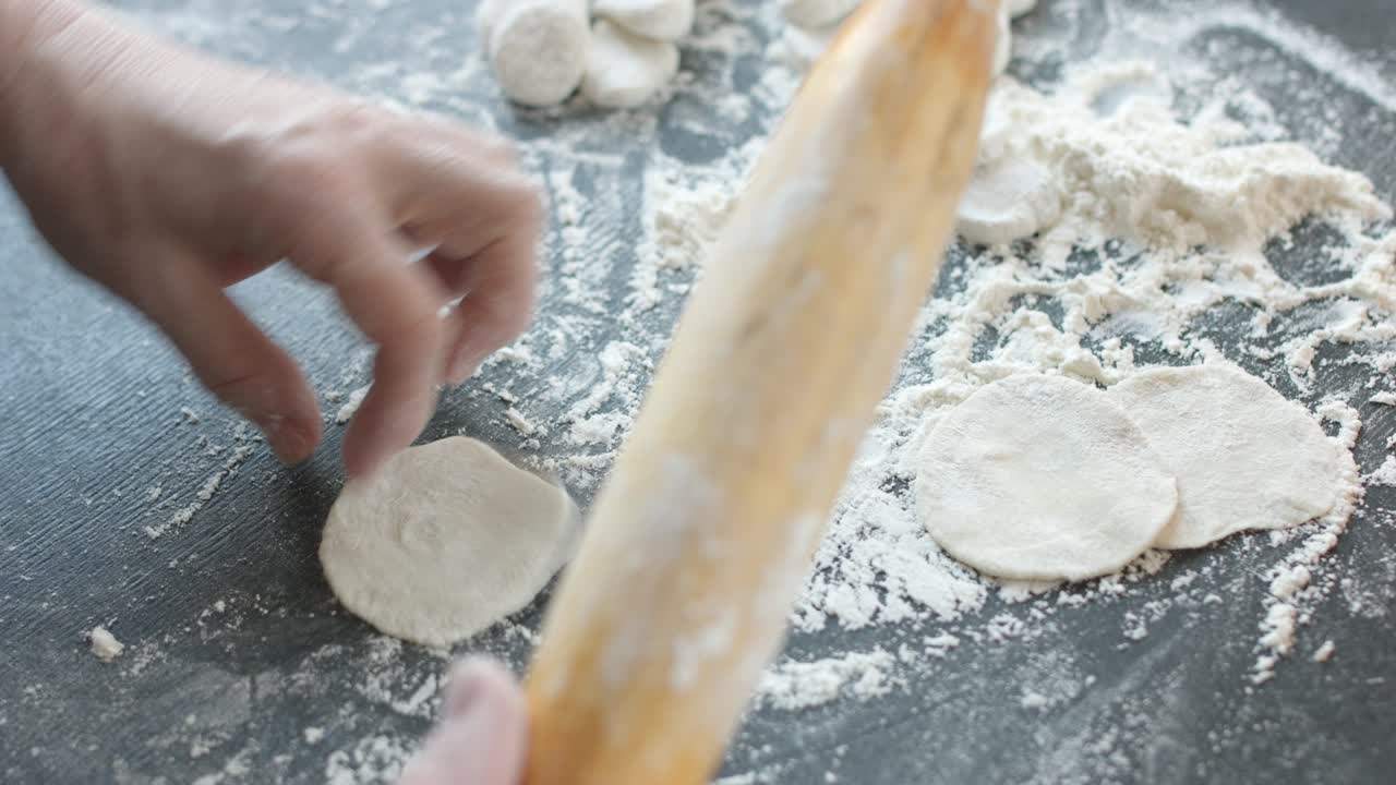 haciendo dumplings de carne con un rodillo de madera.