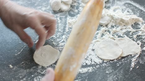 making meat dumpling with wooden rolling pin.