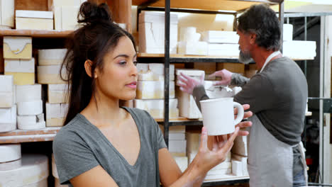 female potter checking mug 4k