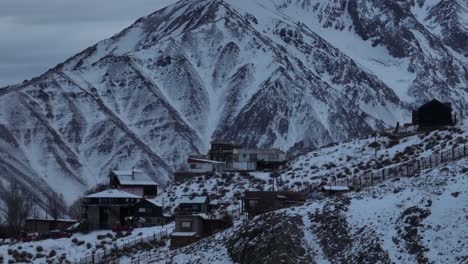 Aerial-parallax-shot-of-Farellones-and-snowy-Andean-Mountains-behind,-Chile