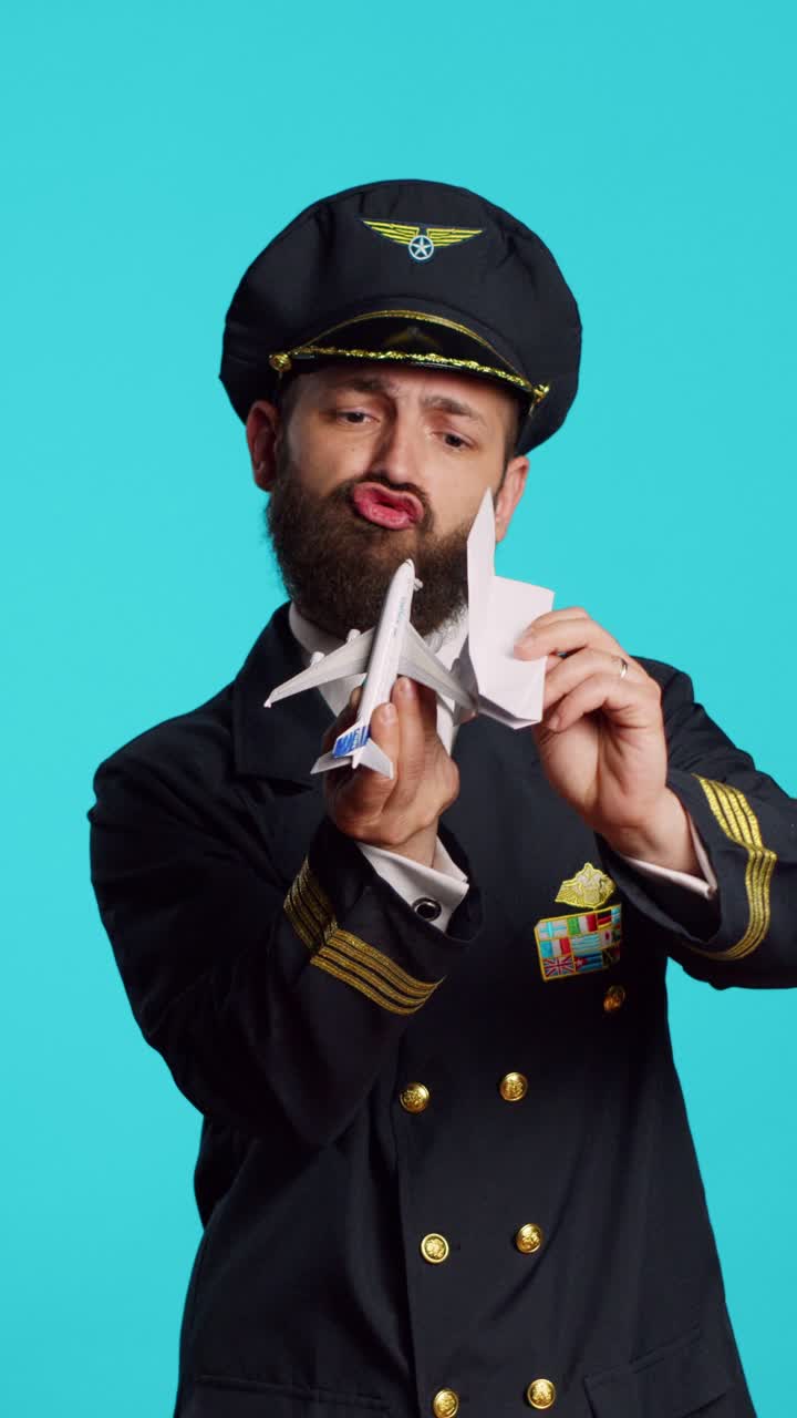 Vertical video: Caucasian man having fun with origami and toy aircraft