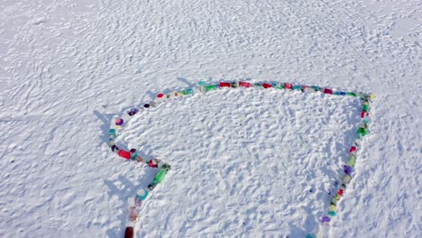 Enorme-Corazón-Hecho-De-Hielo-De-Color-Congelado-Sobre-La-Nieve---Esperanza,-Fe-Y-Oraciones-Para-Que-Mejore-Después-De-La-Pandemia-De-Covid19---Antena-Giratoria-Ascendente