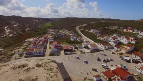 the town of monte clerigo with a car driving on the cliffs