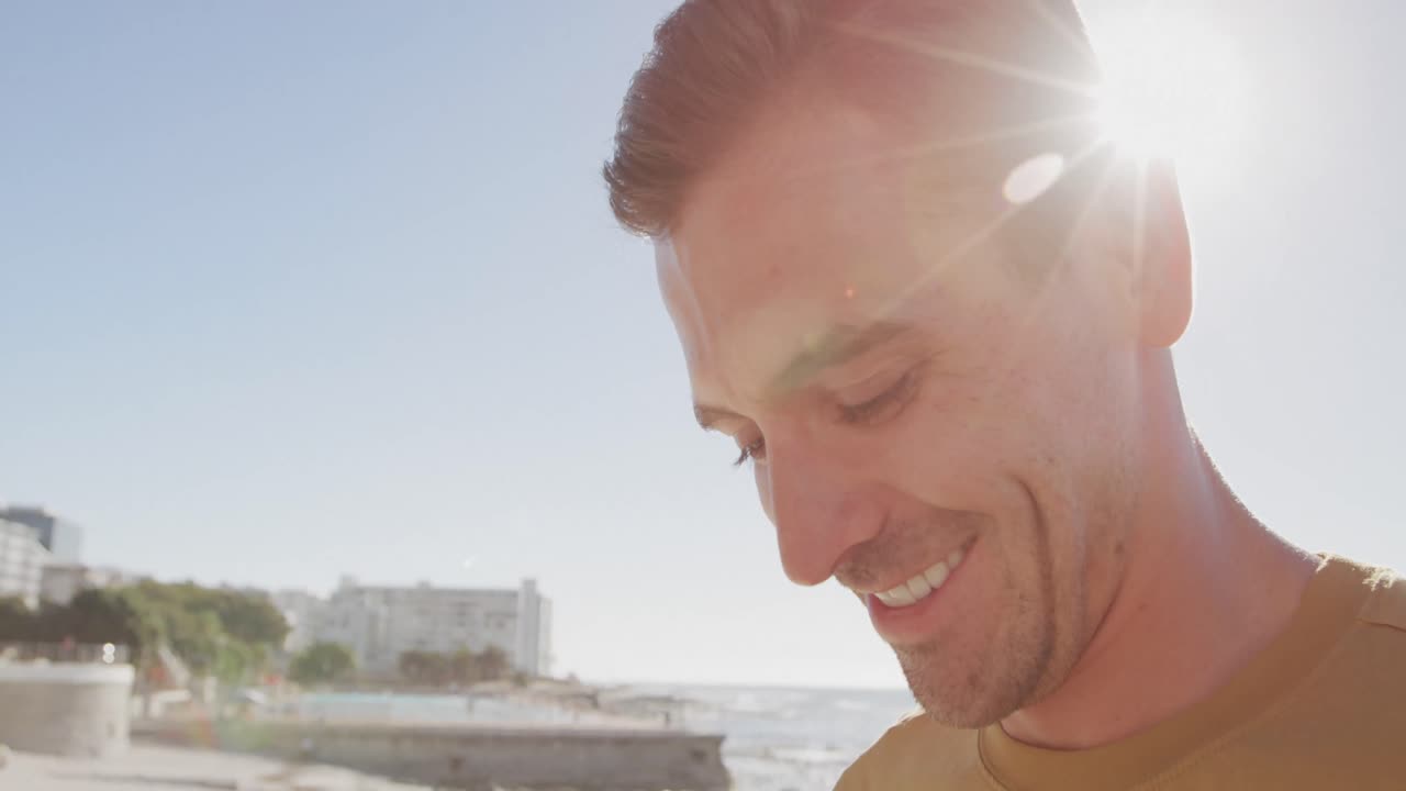 Young man on a beach smiling