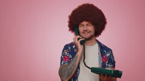 cheerful tourist man secretary talking on wired vintage telephone of 80s, says hey you call me back