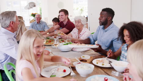 Zeitlupenaufnahme-Einer-Familie-Und-Freunden-Aus-Mehreren-Generationen,-Die-Am-Tisch-Sitzen-Und-Gemeinsam-Essen