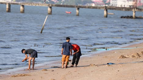 two people cleaning litter on a beach