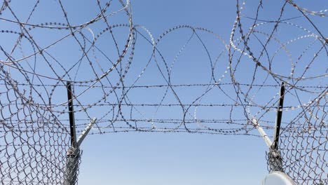barbed wire at prison gate exit | slow move towards opening as birds fly