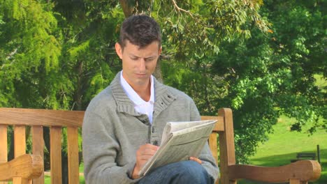 Young-man-doing-crosswords-outdoors