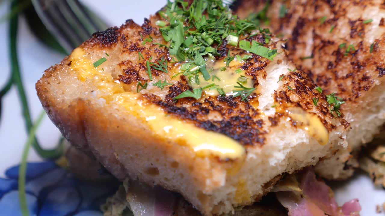 primer plano de un sándwich de queso a la parrilla con mostaza y hierbas