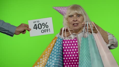 la inscripción de hasta un 40 por ciento de descuento aparece junto a la abuela. mujer celebrando con bolsas de compras