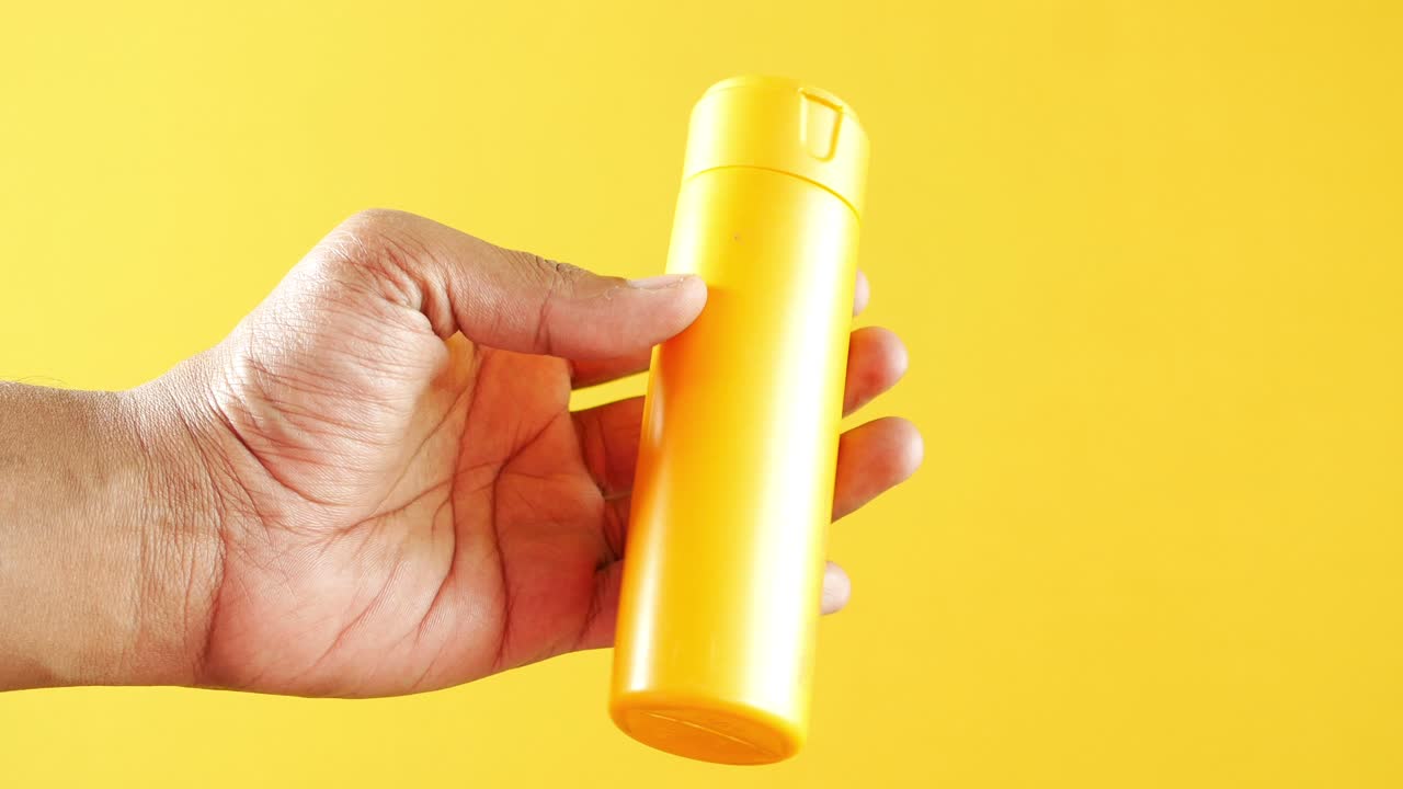 una persona con una crema solar en la mano ,