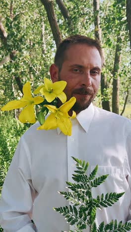 man with yellow lilies in a forest