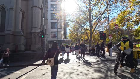 people crossing street at busy melbourne intersection