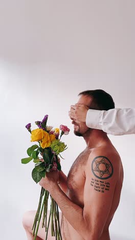 hombre con flores, ojos cubiertos
