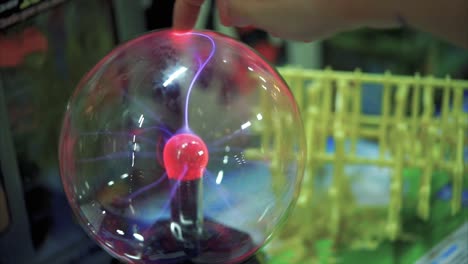 child interacting with a plasma ball