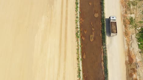 dumper truck with sand is going, passing over highway construction side