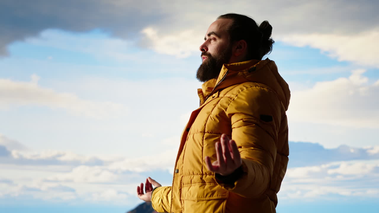 joven explorador alcanzando el pico de la montaña y meditando en la cima