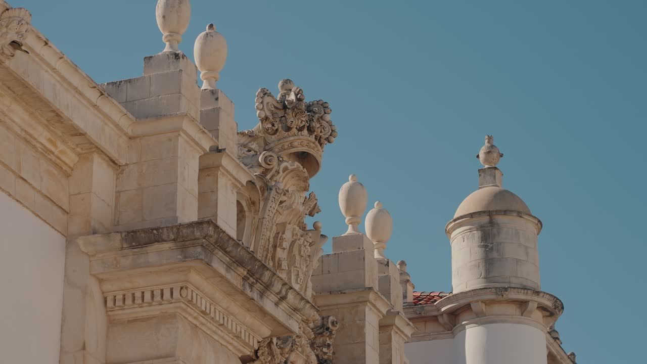 Detailed rooftop architecture of Coimbra University, featuring classic stone adornments
