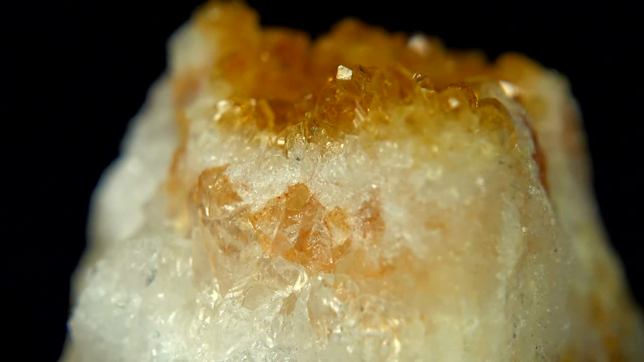 girar sin problemas un mineral de caramelo (citrina) frente a un fondo negro