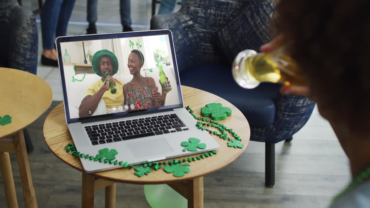 Man having beer on laptop video call celebrating st patrick's day with friends