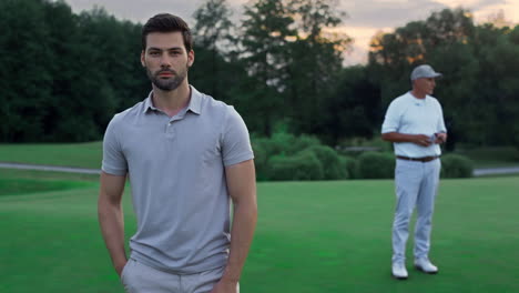 focused model enjoy golf on sport team outdoors. two players standing on course.