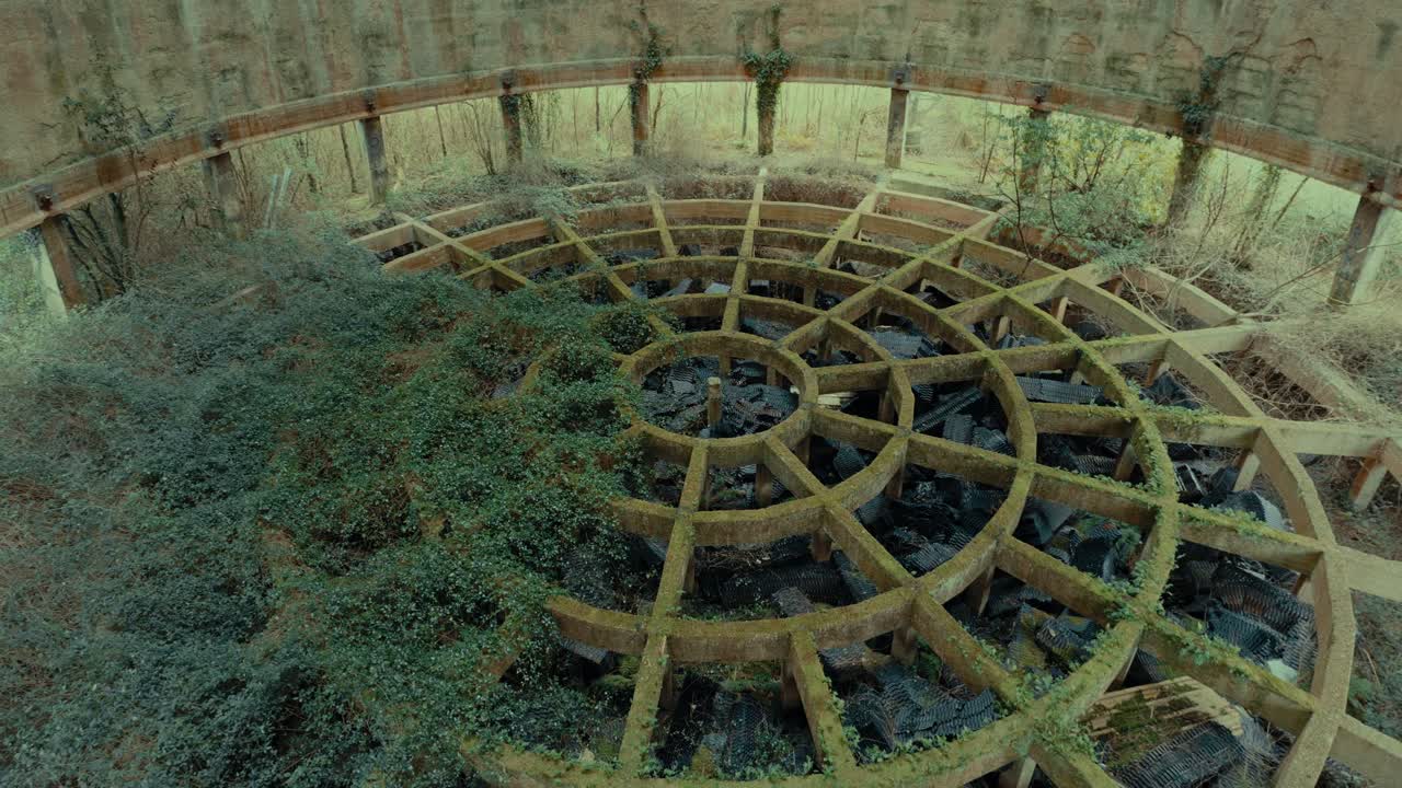 Drone View of Abandoned Circular Concrete Structure Overgrown with Ivy