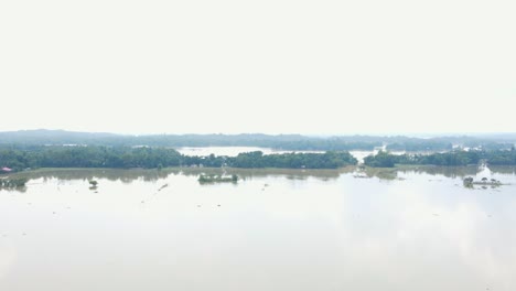 flooded haor landscape with scattered patches of land barely visible in bangladesh, south asia - aerial pullback shot